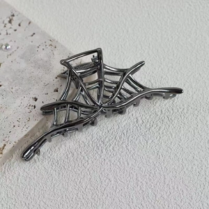Detailed view of Halloween spider web metal hair claw in dark grey gunmetal finish