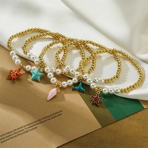 Dettaglio di cinque braccialetti di perline con ciondoli colorati a forma di stella marina e conchiglia
