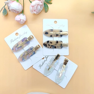 Detail of colorful acetate hair clips with leopard and marble patterns on display cards