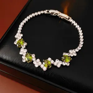 Elegant geometric zircon bracelet with green oval stones and white diamonds on black leather