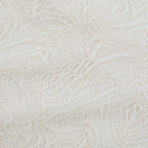 Close-up of off-white embossed jacquard knit fabric showing luxury 3D texture and quality