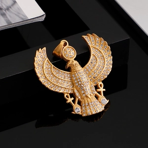 Macro view of iced out gold eagle pendant with Ankh cross symbol and shiny rhinestones