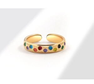 Detail of gold open ring featuring colorful enamel polka dots and adjustable band