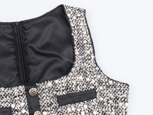 Detail of silver sequins and metal zipper on black and white tweed dress neckline