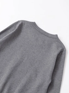Detail view of the gray knit sweater featuring a ribbed crew neck and smooth shoulder seams
