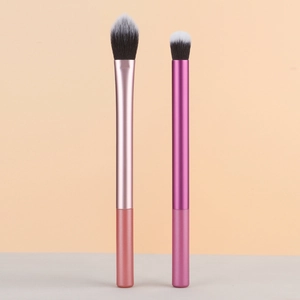 Detail of soft dual-tone synthetic bristles on pink and purple metal makeup brushes