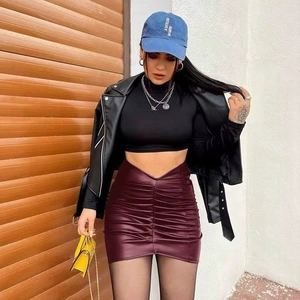 Detail of burgundy PU leather mini skirt with ruched front and stylish high-waisted V-cut