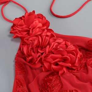 Détail de la broderie fleurie 3D en satin rouge et du tissu en maille sur la robe licou