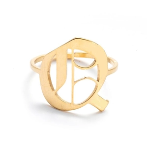 Detailed close-up of a vintage golden stainless steel ring featuring an artistic letter Q