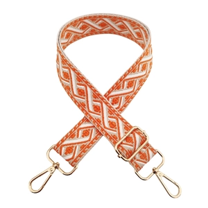 Detail of adjustable orange and beige geometric ethnic bag strap with gold metal clips