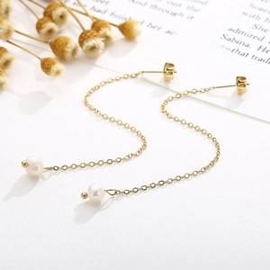 Détail de boucles d'oreilles perles plaquées or 18 carats sur fond de livre élégant