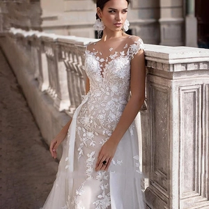 Elegant white lace wedding dress with floral embroidery and illusion neckline