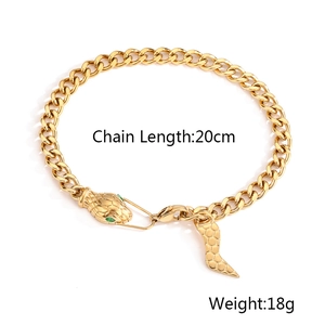 Macro shot of 18K gold-plated snake-head bracelet with green gem eyes, 20cm long