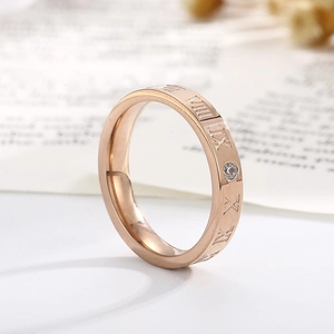 Macro view of rose gold roman numeral ring with a single sparkling diamond inlay