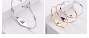 Close-up of dolphin tail bracelets with pavé zircons in silver, gold, and rose gold