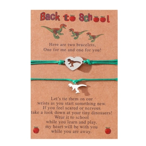 Detail showing two silver dinosaur bracelets with green ropes on a Back to School card