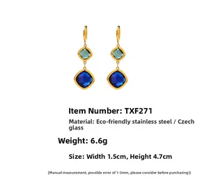 Detail view of geometric gold earrings with green and blue glass stones showing dimensions