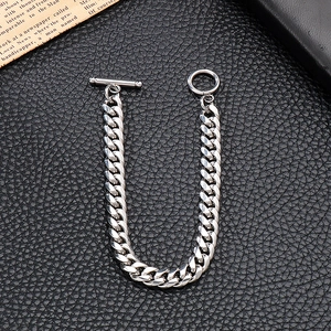 Detailed macro view of silver steel Cuban link chain with T-bar clasp on black leather