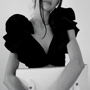 Women's black V-neck bikini top with dramatic ruffle sleeves and high-waisted style