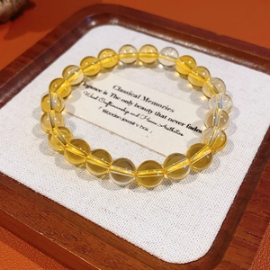 Detail shot of yellow citrine beaded bracelet displayed in an elegant wooden gift box