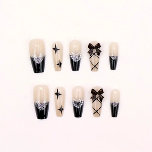 Detailed top view of 10-piece black bow and silver heart press-on nail set