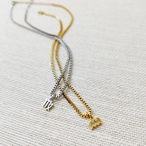 Detail of gold and silver zodiac constellation pendants on 18k box chains