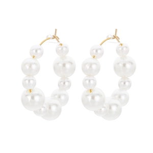U-shaped gold hoop earrings with gradient white pearls on a minimalist white background