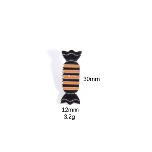 Detail of candy-shaped Halloween enamel pin with orange and black stripes, 30mm size