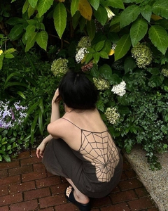 Detailed back view of backless maxi dress featuring intricate spiderweb hollow-out weaving