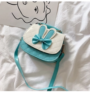 Detail of teal bow crossbody bag for girls with rabbit ears and quilted PU leather texture