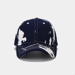 Navy blue graffiti baseball cap with white splatter print and curved brim for outdoor style