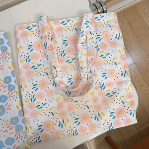 Close-up of printed floral canvas tote bags showing textured fabric and dual shoulder straps