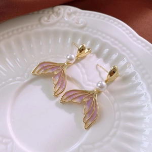 Detail of vintage heart and mermaid tail earrings with pink enamel and faux pearls