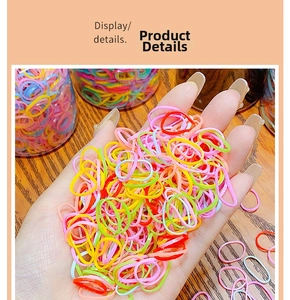 Hand holding colorful high-elastic disposable rubber hair bands in bulk display