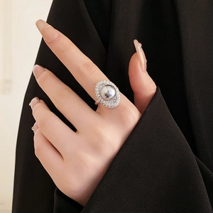 Detail of elegant silver zircon ring with a large grey pearl on a model's hand