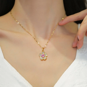 Luxurious gold flower pendant necklace with pink gem and diamonds on a model's neck