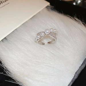 Close-up of silver crossover ring with white pearls and sparkling cubic zirconia stones