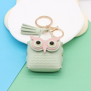 Detail of light green owl coin purse with faux leather texture and gold keychain