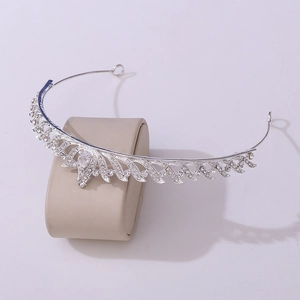 Macro detail of silver crown hairpiece with shimmering zircons and crystals on stand
