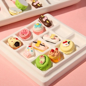 Miniature resin dessert set featuring colorful fake cakes, eclairs, and macarons in a tray