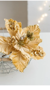 Close-up of champagne velvet poinsettia with gold sequins for Christmas tree decor