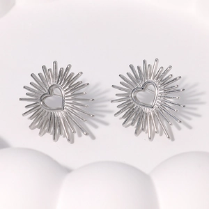 Macro detail of silver heart stud earring with sunburst radial metal lines