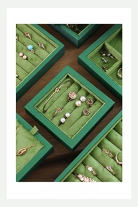 Detailed view of dark green velvet jewelry tray with multi-grid compartments and ring slots