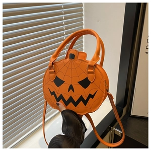 Detail of orange PU leather pumpkin handbag with black face pattern and shoulder strap