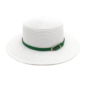 Détail du chapeau de paille blanc avec ruban en similicuir vert et boucle dorée