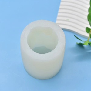 Translucent cylindrical silicone mold for DIY candle making on a light blue background