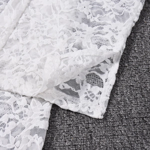 Close-up of white floral lace fabric detailing on backless halterneck jumpsuit