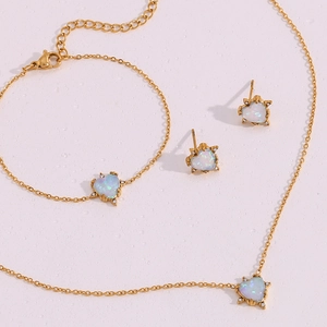 Detail of heart-shaped opal jewelry set including necklace, bracelet and earrings in gold