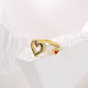 Macro shot of 18K gold plated heart ring with colorful zircons on a white stone base