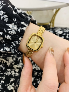 Elegant gold square dial watch for women with Roman numerals and diamond-set markers on wrist